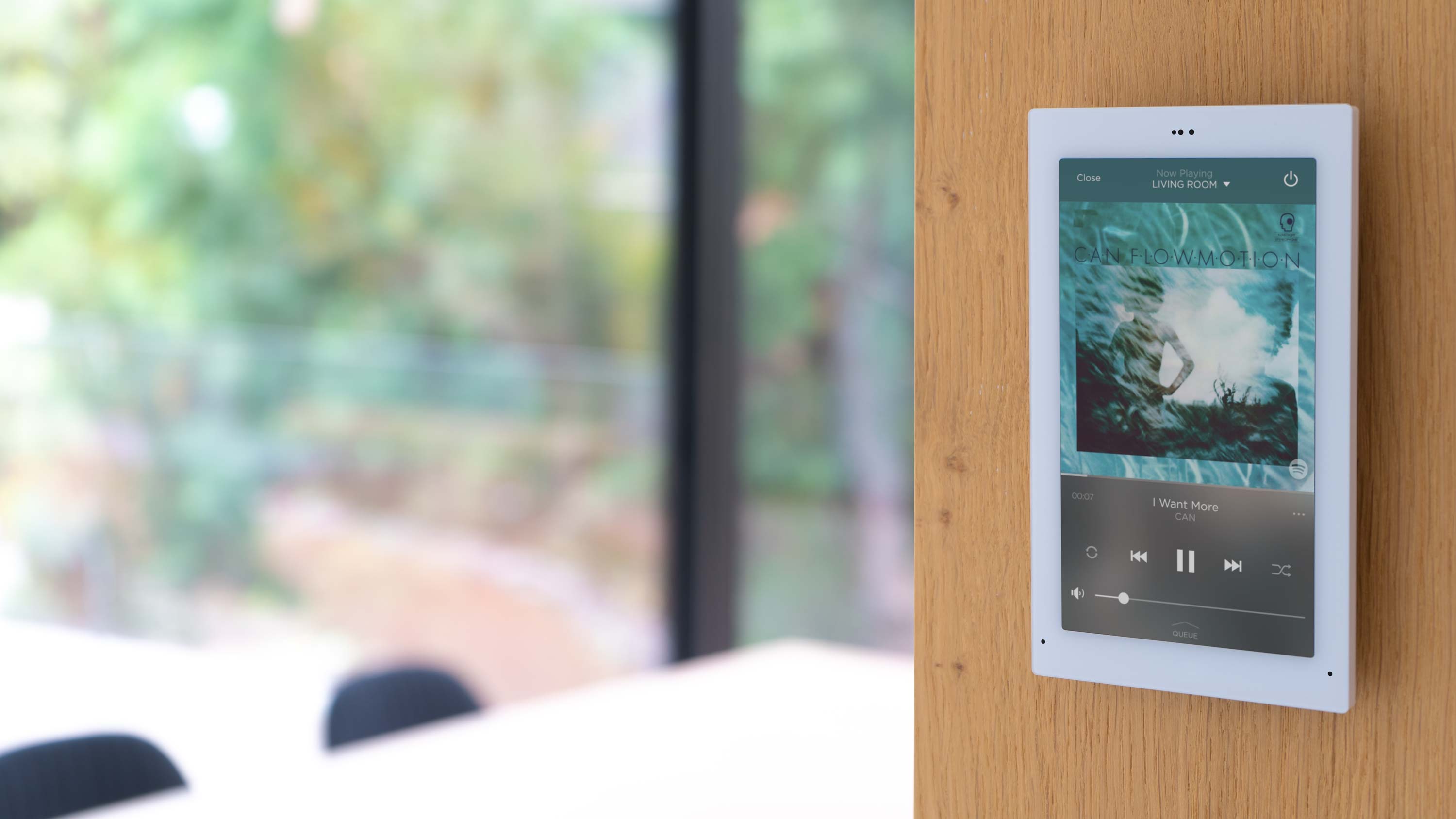 Control4 Touch panel in a able with a traditional home in the background